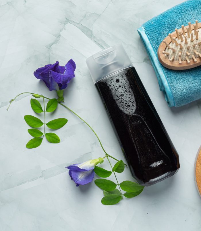 shampoo bottle of Butterfly Pea Flower put on white marble backg